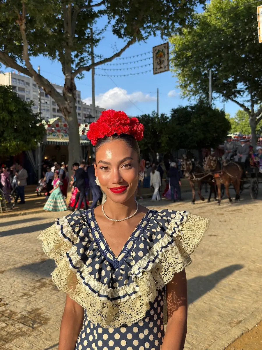 Journalist and travel creator dressed in a traditional flamenco dress at the Feria de Sevilla.