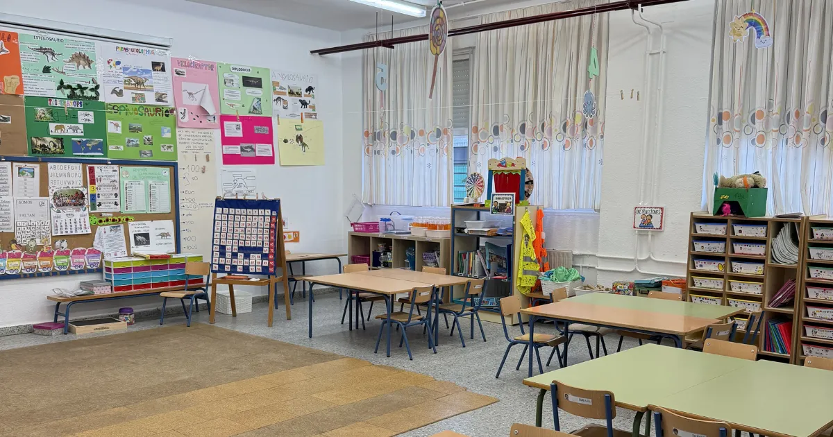 Colorful primary school classroom in Sevilla, Spain, with group tables, child-sized chairs, educational posters, and a rug area—where I taught as a NALCAP auxiliar de conversación.