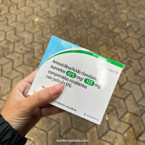 Jenzia holding a box of amoxicillin/clavulanic acid antibiotics from a Spanish pharmacy